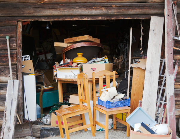 Stored furniture and household items filling a timber shed