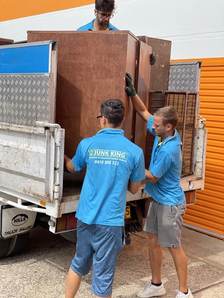 Bulky furniture being loaded onto a Junk King truck
