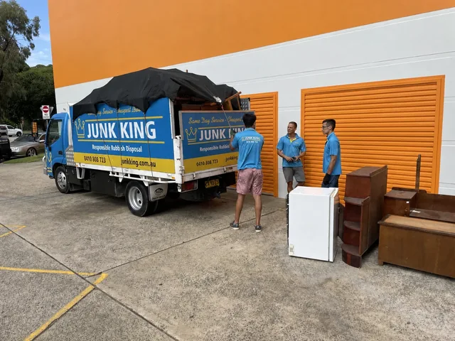 Junk King crew beside a loaded truck at storage units